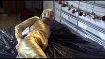 Pia tied and gagged on a bed with ropes wearing a sexy golden shiny nylon rain pants and rain jacket (Video)