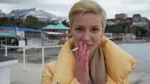 Short cut hair blonde girl is smoking two cork cigarettes