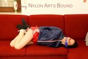 Lucy tied and gagged on a red sofa wearing a supersexy red sprinter and a blue rain jacket (Pics)