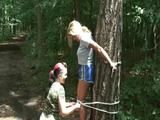 An archive girl tied and gagged on a tree by Jill both wearing shiny nylon shorts (Video)