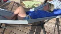 Watching sexy Sonja wearing a grey shiny nylon shorts and a blue rainjacket enjoying the sun (Video)