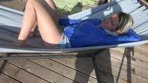 Watching sexy Sonja wearing a grey shiny nylon shorts and a blue rainjacket enjoying the sun (Video)