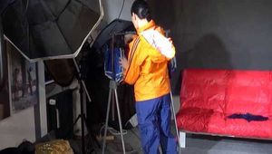 Lucy wearing a sexy blue shiny nylon pants and an orange rain jacket while folding clothes (Video)