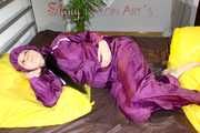 Lucy wearing a supersexy purple rain suit with hood while preparing her bed (Pics)