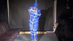Pia being tied and gagged overhead with ropes and a ballgag wearing sexy shiny nylon rainwear (Video)