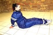 Jill tied and gagged in an old cellar on the floor wearing a shiny blue PVC sauna suit (Pics)