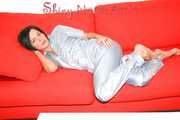 ENNI putting on a very sexy grey shiny nylon adidas rain catsuit and lolling and posing on a sofa (Pics)