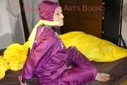 Lucy tied and gagged on a bar in bed wearing a sexy purple rainwear combination (Pics)