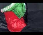 Lucy wearing a green shiny nylon shorts and a green rain jacket lolling on bed (Video)