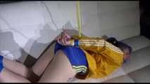 Mara with blue hairs wearing a sexy blue/yellow shiny nylon shorts and a yellow rain jacket tied and gagged with ropes and a ball gag on the sofa (Video)