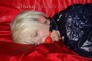 Sexy Courtney being tied and gagged with ropes and a ballgag on a bed wearing dark blue rainwear (Pics)