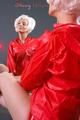 Blonde archive girl posing infront of a mirror wearing sexy red shiny nylon shorts and a red rain jacket (Pics)