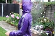 Watching sexy Aiyana wearing a sexy purple shiny nylon shorts and a purple shiny nylon rain jacket enjoying the garden shower (Pics)
