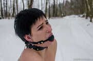 Naked barefoot brunette chained in the snow