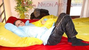 Beautiful Lucy wearing a sexy black rain pants and a lightblue down jacket lolling in bed and posing for you (Pisc)