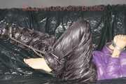 Sandra tied and gagged on a sofa with cuffs and a pillory wearing hot purple down jacket and black down pants (Pics)