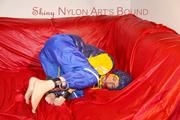 Sonja tied, gagged on a bar and hooded on a sofa wearing a sexy rainwear and downwear combination (Pics)