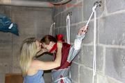 Nicole tied and gagged by Sophie in an red/silver PVC rainsuit in the cellar