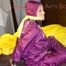 Lucy tied and gagged on a bar in bed wearing a sexy purple rainwear combination (Pics)