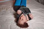 Tied arms and suspended legs in blue leggings