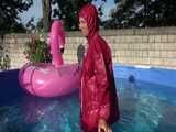 Watch Sandra watering the garden and wetting her shiny nylon oldschool Rainsuit in the Pool