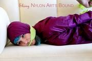 Mara tied and gagged with cloths on a sofa wearing a sexy purple shiny nylon rainwear (Pics)