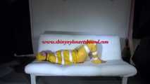 Watching Pia wearing a sexy yellow rainwear being tied and gagged with tape and a ballgag on a sofa (Video)