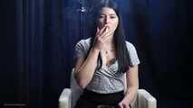 Brunette with mysterious look smoking all white cigarette