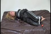 Sophie tied and gagged on a sofa in a shiny black PVC sauna suit (Video)