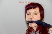 Mara tied and gagged with tape on bed wearing s shiny silver PVC sauna suit (Pics)