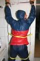 Stella tied, gagged and hooded on an radiator wearing a shiny red/blue rain combination (Pics)