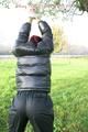 Jill tied and gagged outdoor on a tree wearing a sexy black downjacket and a black rain pants (Pics)