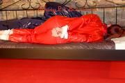 Mara tied and gagged on a princess bed in an old cellar wearing a sexy red sauna suit (Pics)