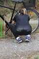 Watch Sandra riding and checking her Bike wearing a shiny nylon Jumpsuit