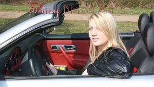 Watching our sexy blonde archive girl wearing a sexy shiny nylon rain pants and a shiny nylon rain jacket and a shiny nylon shorts under the rain pants stretching on the car (Pics)