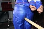 Sexy Sandra being tied and gagged with ropes on a bar overhead wearing a sexy blue raver pants and a blue shiny nylon rain jacket (Pics)