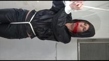 Pia tied, gagged and hooded in a cellar overhead wearing shiny nylon rainwear in black (Video)