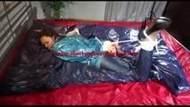 Lulu tied and gagged on a bed wearing a supersexy blue/green rainwear combination (Video)