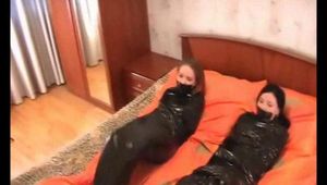 [From archive] Marvita and Chantelle are mummified in black cling film on the bed (video)