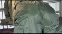 Mara wearing a supersexy green rainwear suit tied and gagged on bed with cuffs and ballgag (Video)