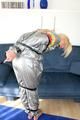 Blond-haired maid tied and gagged with tape wearing a shiny silver PVC sauna suit (Pics)