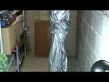 a video with Nicole tied and gagged in a shiny silver PVC sauna suit