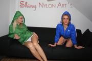 Katharina and Sabrina lolling on a sofa both wearing shiny nylon shorts and rain jackets (Pics)