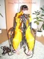 Jill tied, gagged and hooded with a tension belt on a chair wearing a supersexy yellow shiny nylon rainpants and rain jacket (Pics)