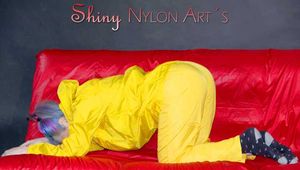 MARA wearing a sexy yellow shiny nylon rain suit lolling and posing on a bed (Pics)