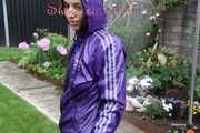 Watching sexy Aiyana wearing a sexy purple shiny nylon shorts and a purple shiny nylon rain jacket enjoying the garden shower (Pics)