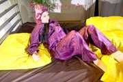 Lucy wearing a supersexy purple rain suit with hood while preparing her bed (Pics)