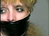 BEAUTIFUL DOE EYED REBECCA IS TIED TO CHAIR, MOUTH STUFFED, CLEAVE, ACE BANDAGE, & ELECTRICAL TAPE GAGGED (D41-4)