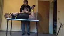 Miri hogtied on the table