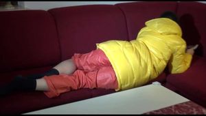 Watching sexy Lucy wearing a orange/yellow shiny nylon downwear combination reaing a magazine and lolling on the sofa (Video)